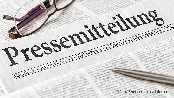 Zeitung mit der Überschrift Pressemitteilung mit brille und kuli